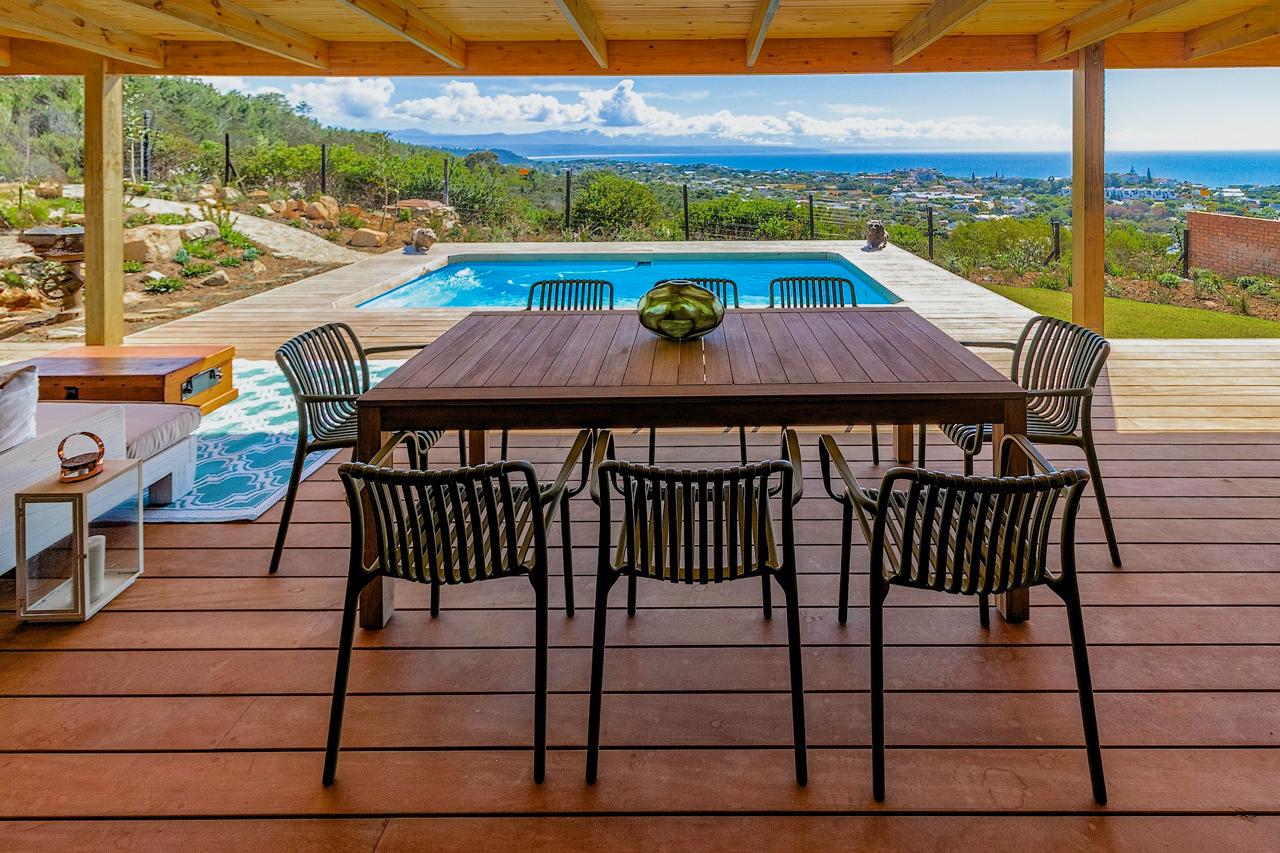 Covered outdoor dining area with pool and sweeping ocean views