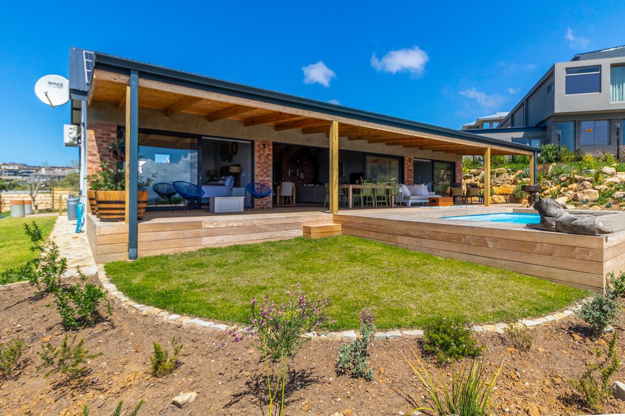 Exterior view showing pool, deck area, and coastal landscape